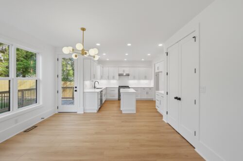 Bright Raleigh new construction interior with continuous warm neutral flooring