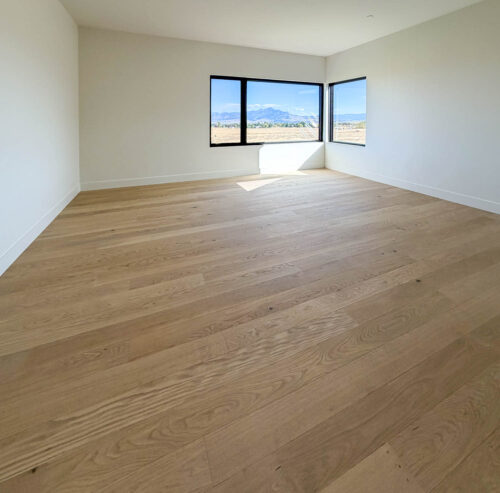 Wide plank European white oak flooring by Real Wood Floors installed in a Bozeman bedroom.