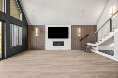 Modern rustic living space with vaulted windows and natural-toned plank flooring