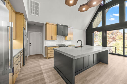 Contemporary cabin kitchen with warm neutral flooring and layered materials