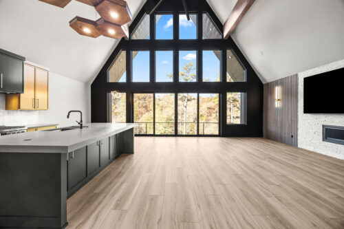 Bright open-concept cabin in Rogers, Arkansas, with wood look flooring unifying seating and architectural elements