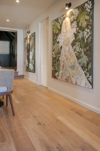 Silvian Luonto European white oak flooring complements patterned seating and colorful statement artwork in a Collierville sitting room.