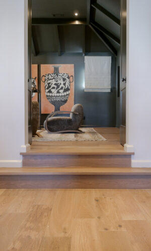 Silvian Luonto hardwood flooring and coordinating wood steps connect contrasting interior spaces in a Collierville show home.