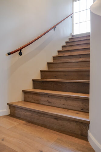 Handmade FloorMade oak stair treads create a cohesive transition from the main living area to the upper level.